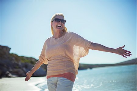 single mature people - Older woman smiling in sun on beach Stock Photo - Premium Royalty-Free, Code: 6113-07762121