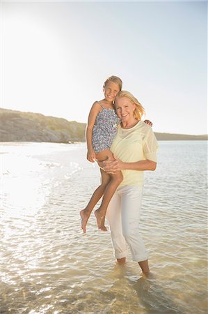 Grandmother holding granddaughter in waves Stock Photo - Premium Royalty-Free, Code: 6113-07762122