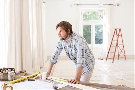 Man overlooking construction table in living space Foto de stock - Sin royalties Premium, Código: 6113-07762213