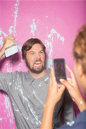simsearch:6113-07762308,k - Woman taking picture with cell phone of man with paintbrush Stock Photo - Premium Royalty-Free, Code: 6113-07762219