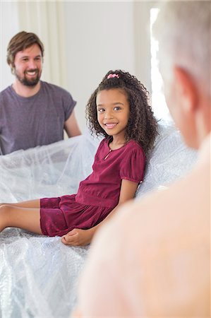 simsearch:6113-07648804,k - Family lifting couch with young girl sitting on top Stock Photo - Premium Royalty-Free, Code: 6113-07762322