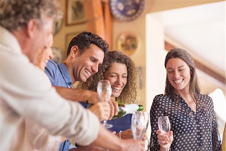 Man pouring drinks to family members Stock Photo - Premium Royalty-Free, Code: 6113-07762566