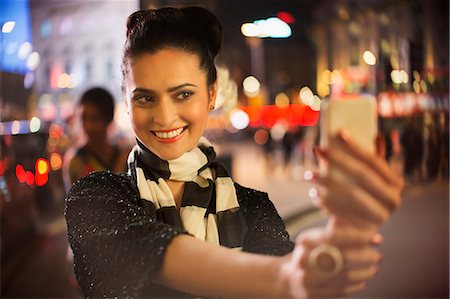 Woman taking picture using cell phone at night Stock Photo - Premium Royalty-Free, Code: 6113-07790265