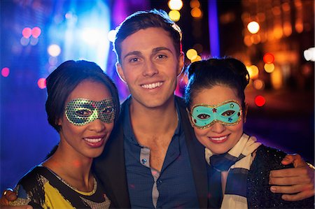 Friends smiling together on city street at night Stock Photo - Premium Royalty-Free, Code: 6113-07790296