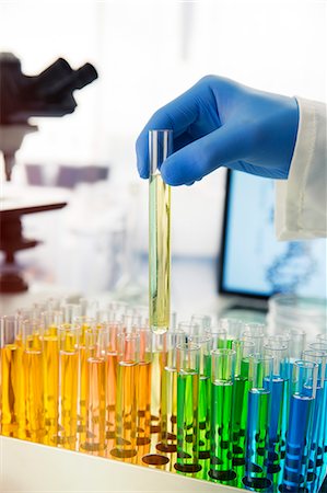 simsearch:6113-07589192,k - Scientist picking test tube out of rack on counter in lab Stock Photo - Premium Royalty-Free, Code: 6113-07790361