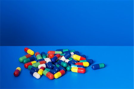 Pile of prescription pills on blue counter Stock Photo - Premium Royalty-Free, Code: 6113-07790335