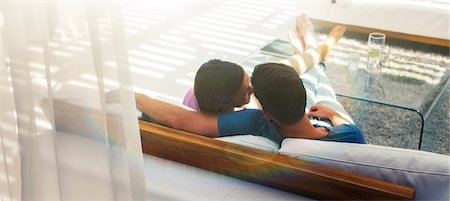 simsearch:6113-07790529,k - Couple relaxing together on sofa in modern living room Stock Photo - Premium Royalty-Free, Code: 6113-07790495