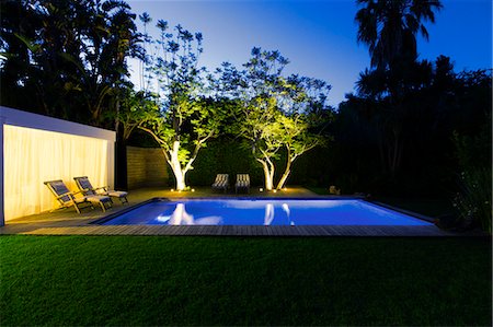 Illuminated swimming pool and trees in backyard at dusk Stock Photo - Premium Royalty-Free, Code: 6113-07790566