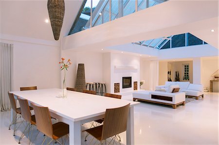 Dining table, sofas and skylights in open dining and living area of modern house Photographie de stock - Premium Libres de Droits, Code: 6113-07790532