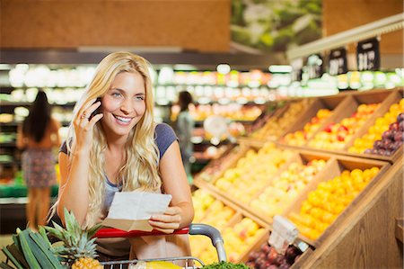 food fruit store - Woman talking on cell phone in grocery store Stock Photo - Premium Royalty-Free, Code: 6113-07790984
