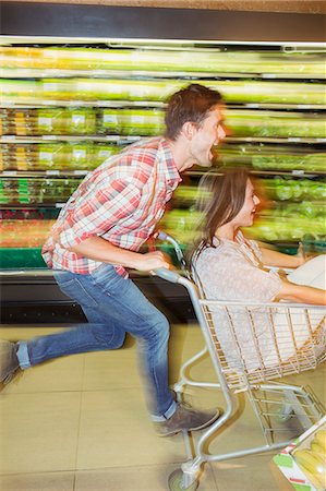 Blurred view of couple playing in grocery store Stock Photo - Premium Royalty-Free, Code: 6113-07791071