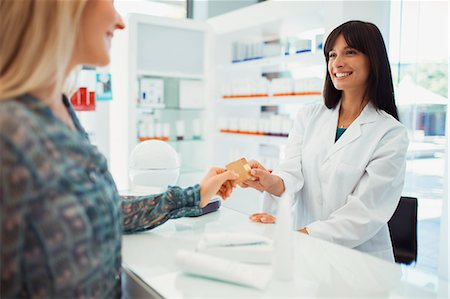 retail shopping - Woman paying with credit card in drugstore Stock Photo - Premium Royalty-Free, Code: 6113-07791143