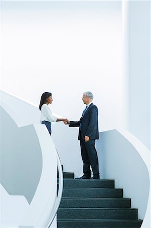 simsearch:6113-06497907,k - Business people shaking hands on stairs of office building Stock Photo - Premium Royalty-Free, Code: 6113-07791387