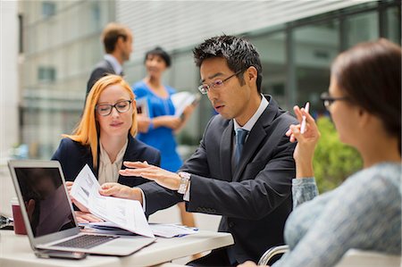 Business people talking at table outside of office building Stock Photo - Premium Royalty-Free, Code: 6113-07791385