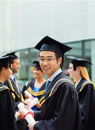simsearch:6113-07791483,k - Student in cap and gown standing with friends Stock Photo - Premium Royalty-Free, Code: 6113-07791497
