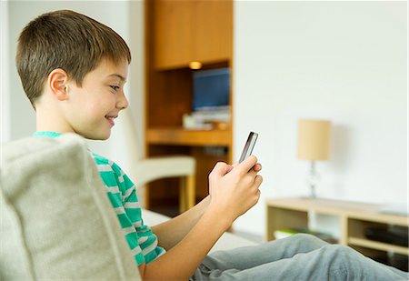 simsearch:6113-07731119,k - Boy using cell phone in living room Stock Photo - Premium Royalty-Free, Code: 6113-07730516