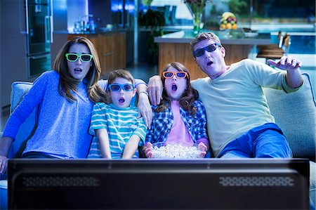 simsearch:400-05749623,k - Family watching 3D television in living room Stock Photo - Premium Royalty-Free, Code: 6113-07730531