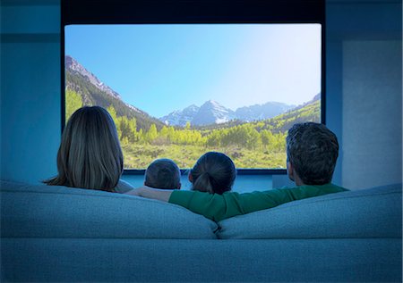 sitting back - Family watching television in living room Stock Photo - Premium Royalty-Free, Code: 6113-07730538