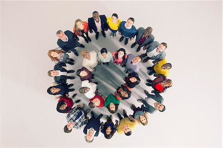 Portrait of diverse crowd in huddle Stock Photo - Premium Royalty-Free, Code: 6113-07730696