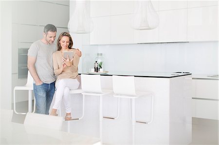 simsearch:6113-07730780,k - Couple using digital tablet in kitchen Stock Photo - Premium Royalty-Free, Code: 6113-07730747