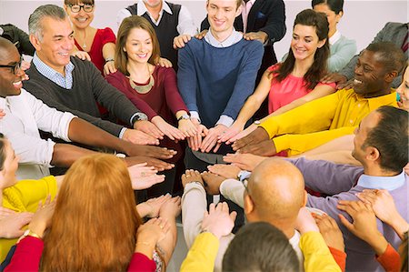 simsearch:6113-07730619,k - Business people with arms outstretched in huddle Stock Photo - Premium Royalty-Free, Code: 6113-07730700
