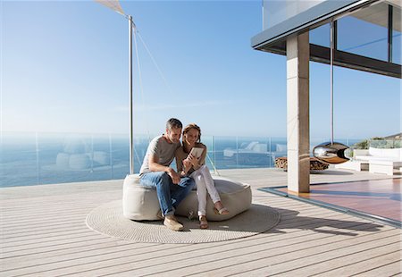 Couple using digital tablet on modern balcony Photographie de stock - Premium Libres de Droits, Code: 6113-07730802