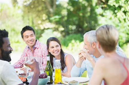 simsearch:6113-07731034,k - Friends talking at table outdoors Stock Photo - Premium Royalty-Free, Code: 6113-07730990