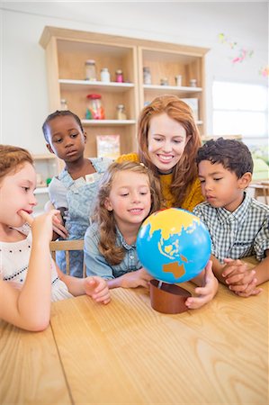 Students and teacher examining globe in classroom Foto de stock - Sin royalties Premium, Código: 6113-07731171