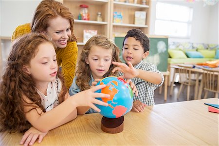 sala de clases - Students and teacher examining globe in classroom Foto de stock - Sin royalties Premium, Código: 6113-07731187