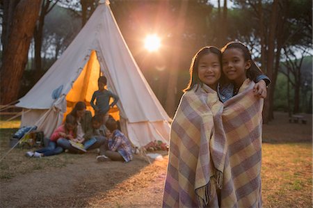 Girls wrapped in blanket at campsite Stock Photo - Premium Royalty-Free, Code: 6113-07731192