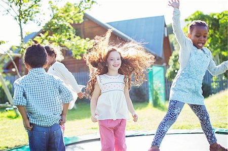 simsearch:6113-07146985,k - Children jumping on trampoline outdoors Foto de stock - Sin royalties Premium, Código: 6113-07731133