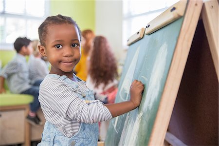 preschool - Girl drawing on chalkboard in classroom Stock Photo - Premium Royalty-Free, Code: 6113-07731138