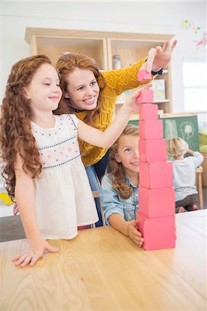 Students and teacher stacking blocks in classroom Foto de stock - Sin royalties Premium, Código: 6113-07731205