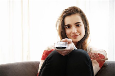 Teenage girl watching television on sofa Foto de stock - Sin royalties Premium, Código: 6113-07731334