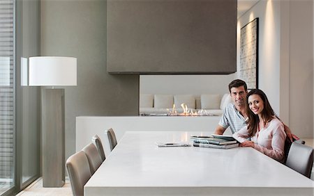 Portrait of happy couple sitting in dining room with books and digital tablet on table Photographie de stock - Premium Libres de Droits, Code: 6113-07808201