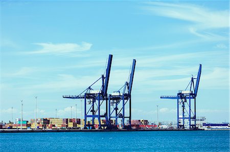 Cranes and cargo containers at waterfront Stock Photo - Premium Royalty-Free, Code: 6113-07808381