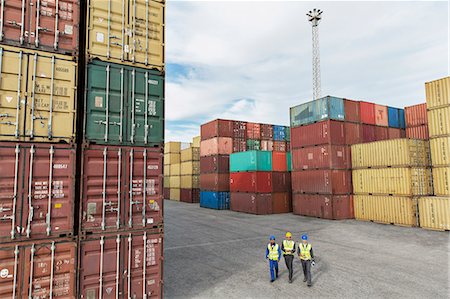 Businessmen and worker walking near cargo containers Foto de stock - Sin royalties Premium, Código: 6113-07808333