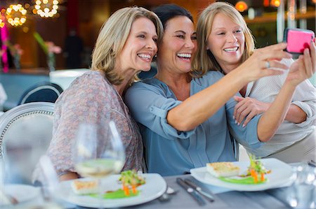 simsearch:614-07806346,k - Female friends taking selfie in restaurant Foto de stock - Sin royalties Premium, Código: 6113-07808583