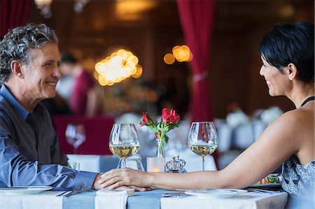 romantic couple holding hands - Mature couple sitting face to face and holding hands at restaurant table Foto de stock - Sin royalties Premium, Código: 6113-07808535
