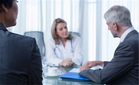 simsearch:6108-06907153,k - Female doctor, man and woman talking at table in conference room Stock Photo - Premium Royalty-Free, Code: 6113-07808712