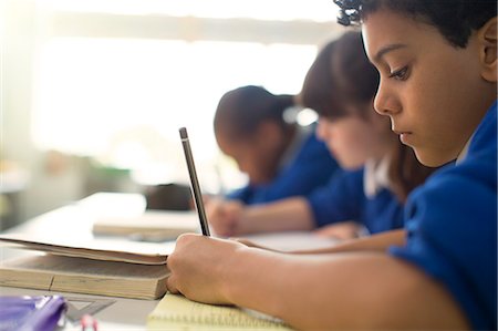 simsearch:614-06895765,k - Pupils writing in notebooks at desks in classroom Stock Photo - Premium Royalty-Free, Code: 6113-07961427
