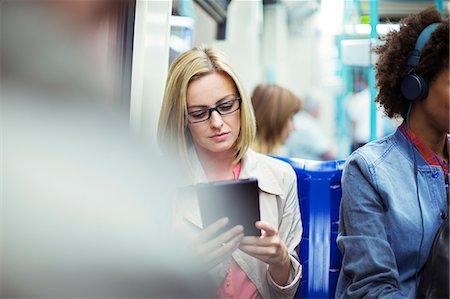 Businesswoman using digital tablet on train Stock Photo - Premium Royalty-Free, Code: 6113-07961594