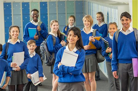 Group portrait of schoolchildren wearing school uniforms standing in corridor and smiling Stock Photo - Premium Royalty-Free, Code: 6113-07961523
