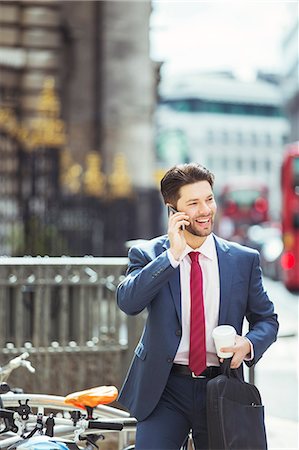 Businessman talking on cell phone on city sidewalk Stock Photo - Premium Royalty-Free, Code: 6113-07961652