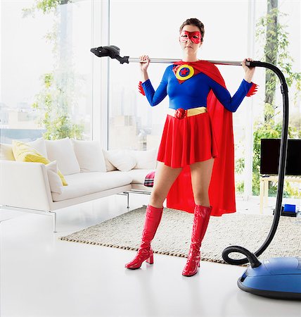 Superhero holding vacuum in living room Stock Photo - Premium Royalty-Free, Code: 6113-07961689