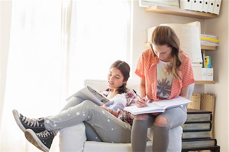 Two teenage girls doing homework in room Stock Photo - Premium Royalty-Free, Code: 6113-07991996