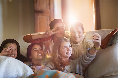 simsearch:614-06043438,k - Group of smiling teenagers taking selfie on sofa in living room Photographie de stock - Premium Libres de Droits, Code: 6113-07992009