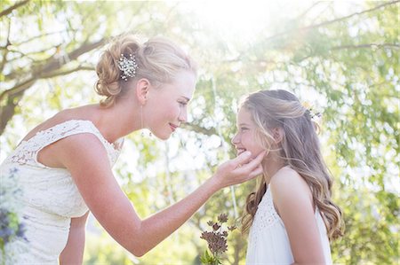 dressing - Bride and bridesmaid facing each other in domestic garden during wedding reception Stock Photo - Premium Royalty-Free, Code: 6113-07992154