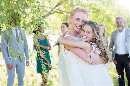simsearch:614-06895765,k - Bride embracing bridesmaid at wedding reception in domestic garden Stock Photo - Premium Royalty-Free, Code: 6113-07992170