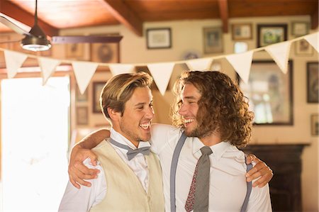 Bridegroom and best man embracing in domestic room Stock Photo - Premium Royalty-Free, Code: 6113-07992180